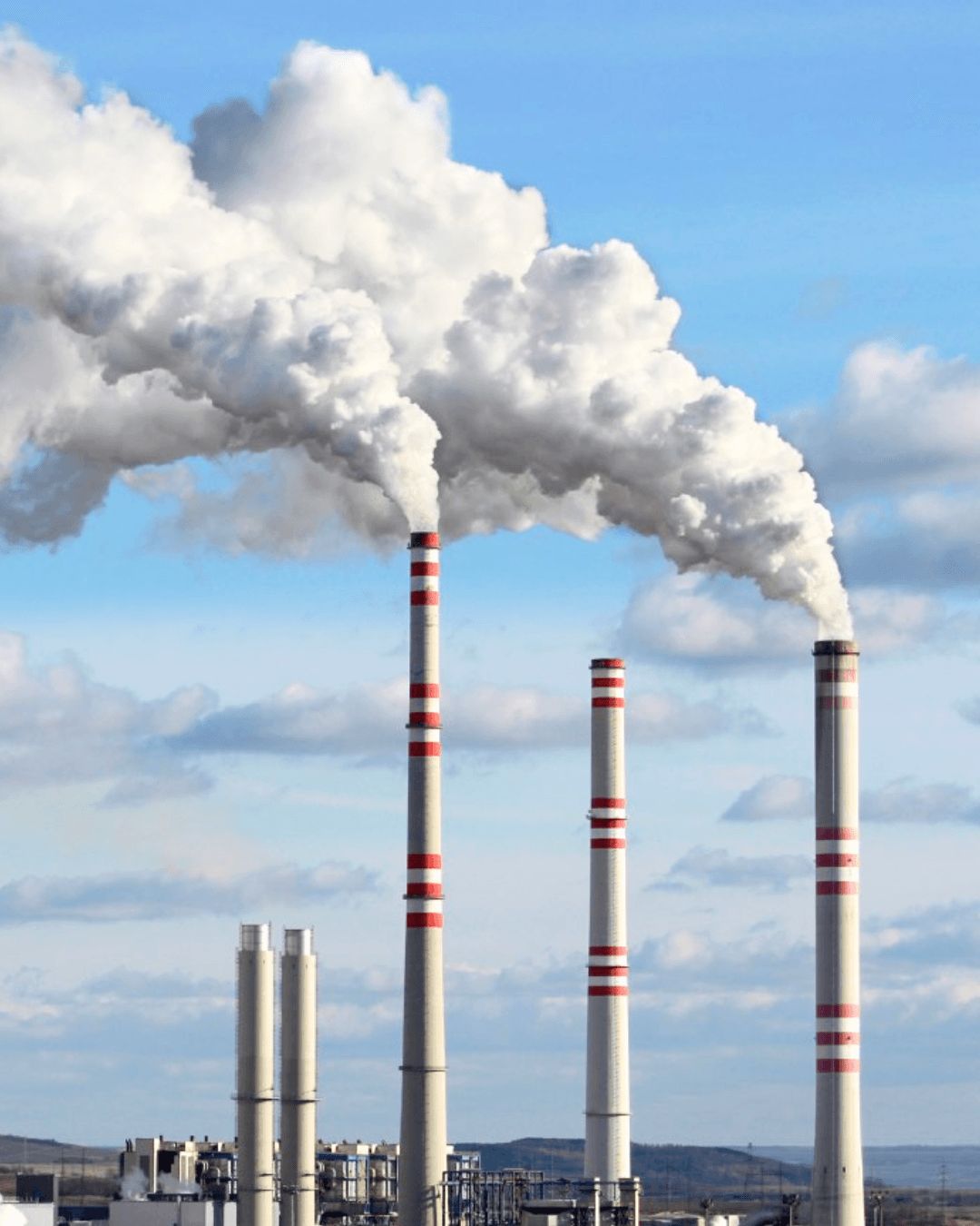 Industrial stacks releasing visible plumes into the sky